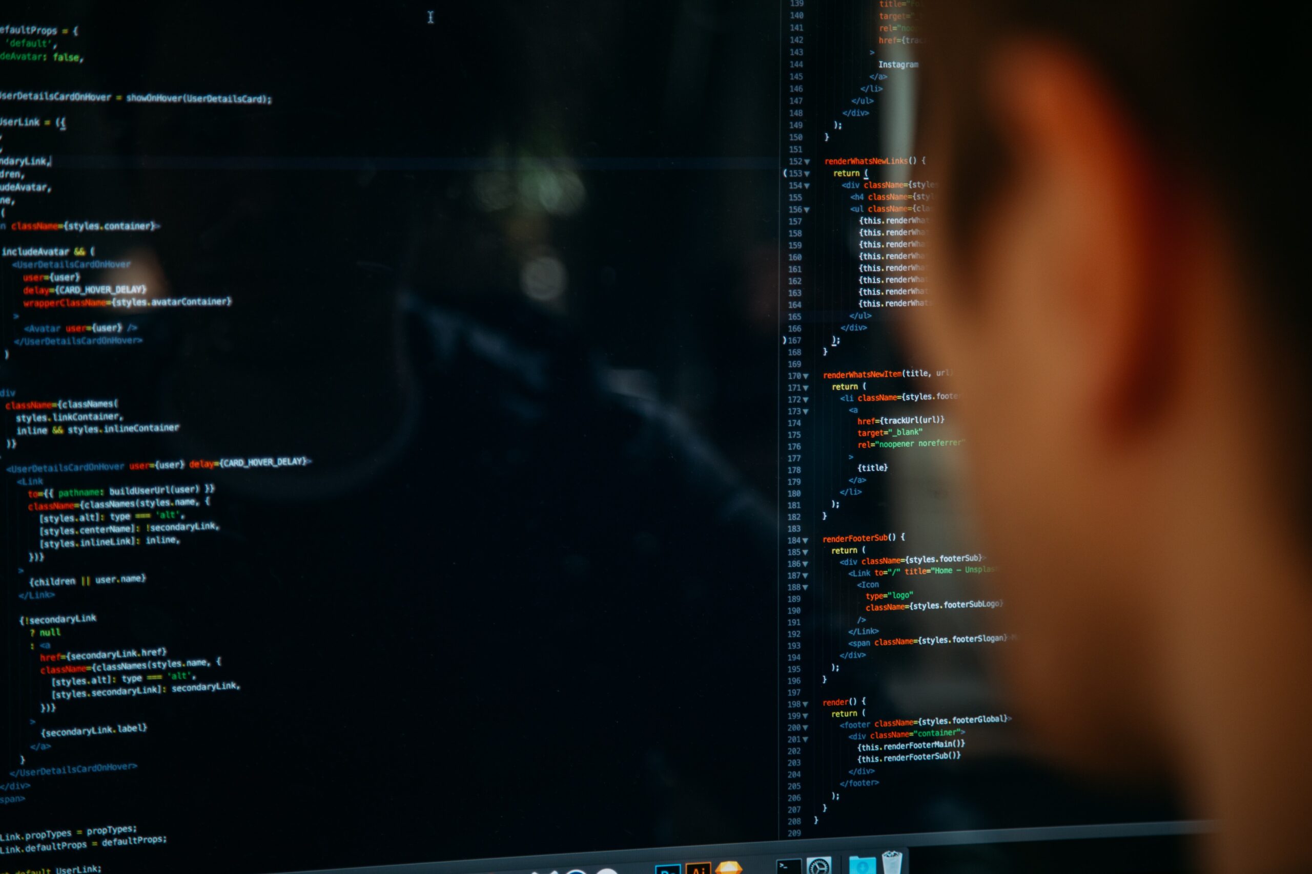 A person looks at a computer screen displaying lines of colorful code, with text in various colors on a dark background. The person's face is blurred in the foreground.